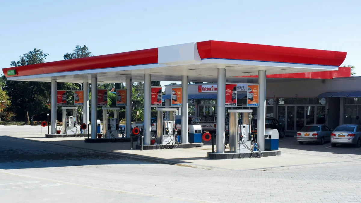 station-service-pompes-multiples-jour-soleil Grande station-service avec plusieurs pompes à carburant en plein soleil